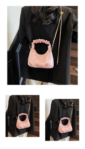 Détail du sac rose brillant avec poignée froncée et fine bandoulière chaîne dorée