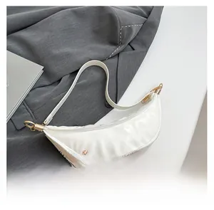 Close-up of a white dumpling bag featuring pleated PU leather and gold-toned metal zipper