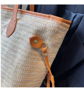 Detail of high-quality golden hardware and leather trim on a woven straw tote bag
