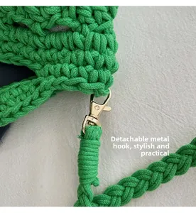 Detail of detachable gold metal lobster clasp on a green woven straw bucket bag