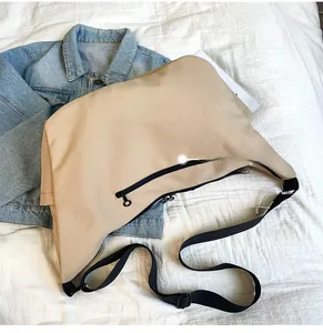 Detail view of the khaki crossbody bag back side showing black zipper and nylon strap