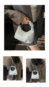 Détail du sac à main bleu clair froncé avec bandoulière chaîne et finition vernie chic