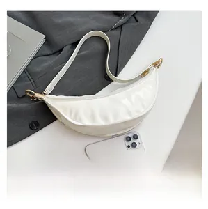 Detail of white leather hobo bag with gold metal buckle and smooth zipper closure