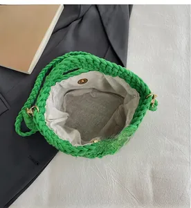 Detail view showing green woven bucket bag interior with grey lining and magnetic metal clasp