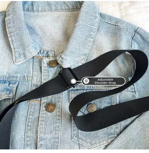 Detail of adjustable black fabric strap and matte metal buckle on light blue denim bag