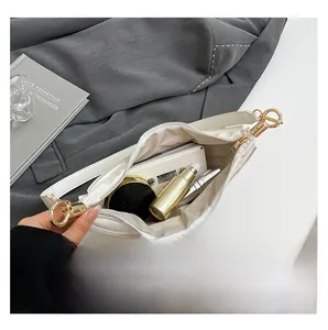 Interior view of the white crossbody bag showing spacious storage and golden hardware