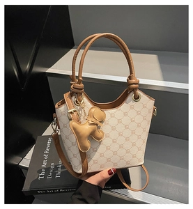 Détail du sac seau avec imprimé classique et charmant pendentif en cuir en forme de chien