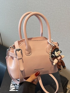 Borsa a mano in ecopelle rosa con manici e un simpatico ciondolo a bambolina