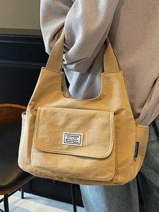 Minimalist canvas shoulder bag in khaki with large front pocket and side storage