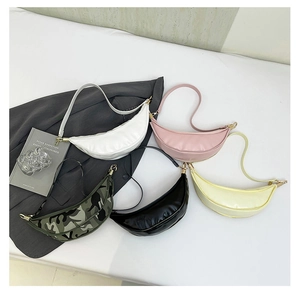 Flat lay of multiple PU leather crescent underarm bags in various colors for 2025 fashion