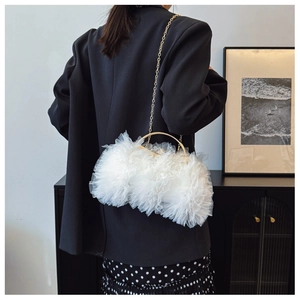 Detail of white layered mesh clutch bag featuring gold handle and elegant chain strap
