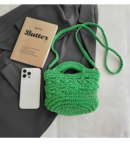 Detail of bright green hand-woven handbag with crochet texture on a dark blazer