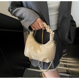Détail du sac à main blanc cassé avec poignée froncée et bandoulière en chaîne dorée