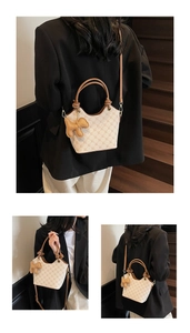 Détails du sac seau monogramme beige avec poignées marron et breloque chien en cuir