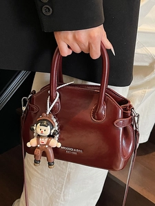 Borsa a mano retrò in pelle cerata rosso scuro con manici cilindrici e ciondolo bambola