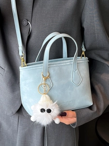 Minimalist light blue bucket bag with leather texture and cute plush charm pendant