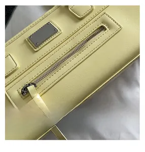 Gros plan du sac porté épaule jaune avec fermeture éclair en métal et coutures précises