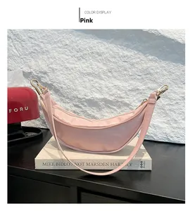 Detailed close-up of a pink patent leather crescent bag on an art book surface
