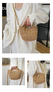 Detail of hand-woven hollow straw bucket bag with natural khaki texture and thick strap