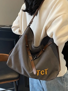 Charcoal canvas hobo tote bag with brown leather straps and yellow TCT embroidery detail