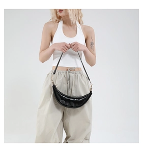 Minimalist black crescent bag with smooth faux leather and golden hardware on shoulder