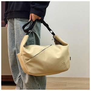 Detail of beige nylon messenger bag with metal MS logo and wide adjustable black strap