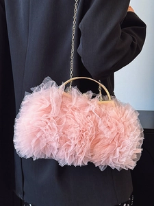Pink pleated tulle handbag with gold metal handle and chain in a stylish model view