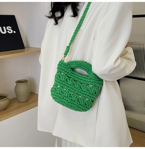 Detail of green hand-woven crochet bag with thick texture and gold metal hardware