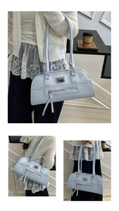 Détail du sac sous le bras bleu clair avec plaque en métal et pochette zippée décorative