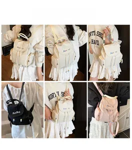 Close-up of minimalist nylon backpacks in cream black and pink with magnetic buckle closure