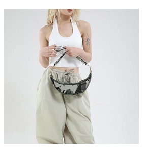 Detail of camouflage crescent bag with wide strap worn by model in streetwear style