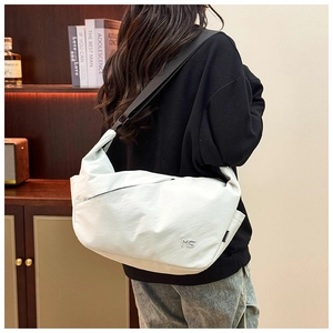 Detailed view of white nylon shoulder bag with adjustable strap and metallic logo