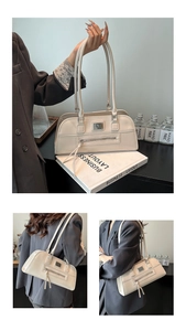 Vue détaillée du sac sous le bras blanc crème avec plaque en métal et poche zippée