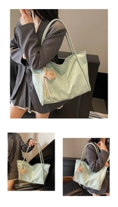 Detail view of mint green tote bag featuring a cute brown plush bear charm accessory