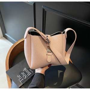 Detailed view of pink litchi grain leather bucket bag with silver metal lock closure