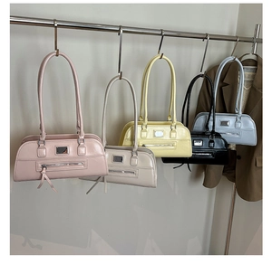 Détail de sacs sous les aisselles en cuir coloré avec glands et plaque métallique