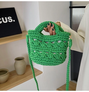 Detail of green woven bucket bag showing diamond texture and gold metal buckle