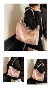 Pink soft leather tote bag detail with cute brown teddy bear charm and striped tassel