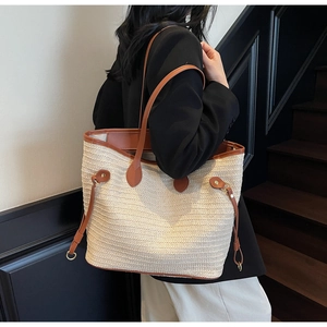 Detailed macro view of woven straw texture and premium brown leather handle on tote bag