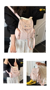 Pink nylon backpack detail showing drawstring closure, magnetic flap, and top ring handle