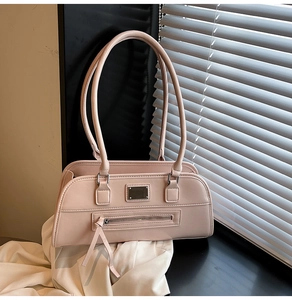 Détail d'un sac à main rectangulaire rose clair avec double bandoulière et poche zippée