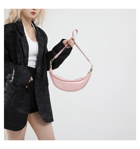 Detail of pink crescent moon bag featuring smooth synthetic leather and gold metal hardware