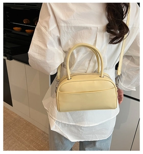 Detailed view of the pale yellow leather pillow bag showing the adjustable shoulder strap