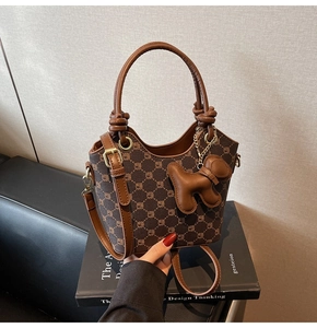 Vue détaillée du sac seau monogramme avec poignée en cuir nouée et pendentif chien