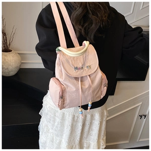 Pink nylon backpack detail featuring side zippers and MeaRey embroidery on black hoodie