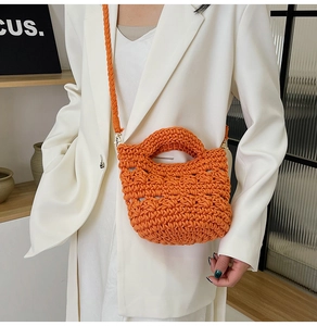 Detail of orange hand-woven crochet bag featuring chunky rope texture and long strap