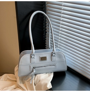 Détail d'un sac sous les bras rectangulaire bleu clair avec texture en cuir et zip en métal
