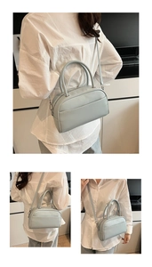 Detail of light blue crossbody bag with silver hardware and front pocket shown on model