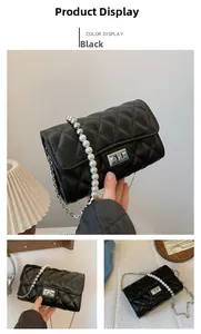 Détail d'un sac bandoulière noir matelassé avec bandoulière élégante en perles et argent