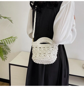 Detailed shot of a white woven crochet bag featuring hollow patterns and golden hardware